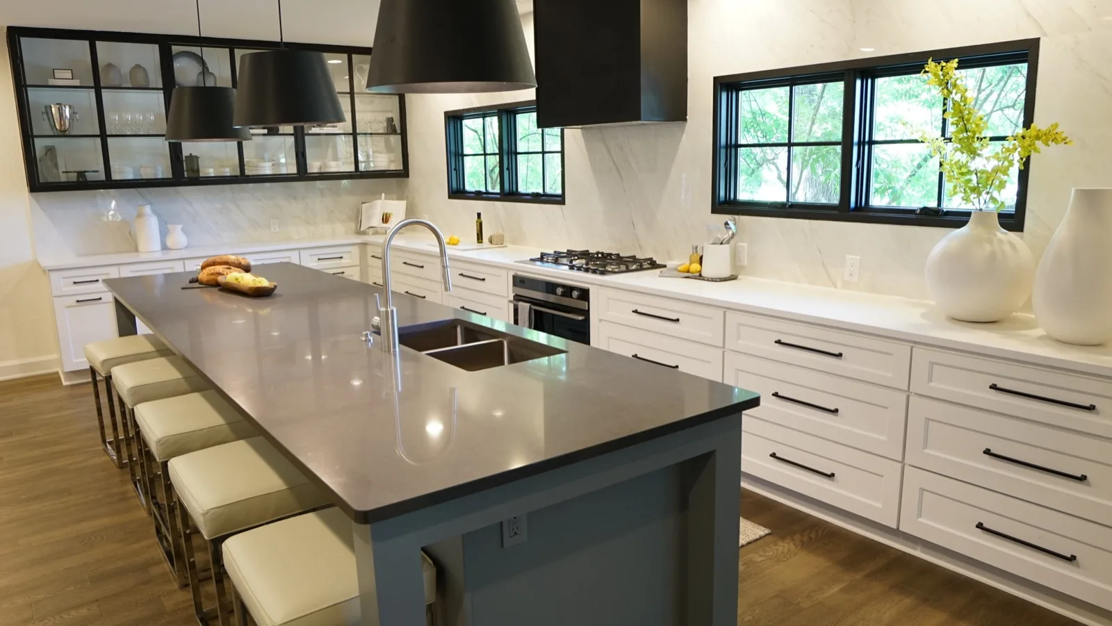 Kitchen we remodeled with gray quartz island, white quartz perimeter counters and black-framed windows